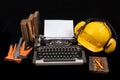 A construction helmet on an old typewriter. Books and accessories for the engineer