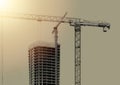 Construction of highrise apartment tower with steel structure, crane, and dotted facade. Urban Royalty Free Stock Photo