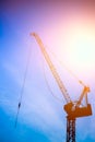 Construction hoisting cranes silhouette against blue sky