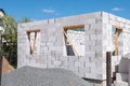 Construction of a house from gas silicate white blocks. A mountain of gravel near an unworthy house