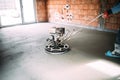 Construction industrial worker finishes concrete screed with trowel machine Royalty Free Stock Photo