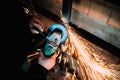 Construction industry details - close up of metalworker using disc grinder for cutting metal