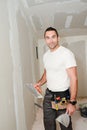 Construction industry worker with tools plastering walls and renovating house in construction site Royalty Free Stock Photo