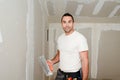 Construction industry worker with tools plastering walls and renovating house in construction site