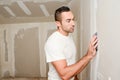 Construction industry worker with tools plastering walls and renovating house in construction site Royalty Free Stock Photo