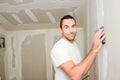 Construction industry worker with tools plastering walls and renovating house in construction site