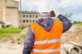 Construction inspector filming with tablet PC near building