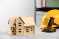 Construction and land law concepts. House model, gavel and hard hat on white table indoors Royalty Free Stock Photo