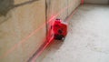 The construction laser level is on the floor. The beam is directed at the wall. Aligning the walls with a laser level Royalty Free Stock Photo