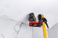 Construction laser level on tripod on white ceiling background. Royalty Free Stock Photo