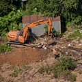 Construction machinery destroys illegal buildings in the forest