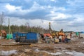 Construction machinery in a construction parking lot, mud and slush on the road. Warehouse of spare parts for construction Royalty Free Stock Photo