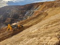 Construction machinery in the process of profiling a bench in an open-pit mine Royalty Free Stock Photo