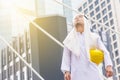 Construction and maintenance concept, Arab Middle Eastern architect holding yellow helmet and checking tablet PC with city backgro Royalty Free Stock Photo