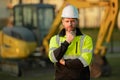 Construction man with excavator at industrial site. Worker in helmet build with bulldozer. Engineer work with builder Royalty Free Stock Photo