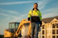 Construction man with excavator at industrial site. Worker in helmet build with bulldozer. Engineer work with builder Royalty Free Stock Photo