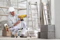 Construction man worker measure with level laser wear hard hat and protective glasses at interior building site