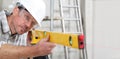 Construction man worker measure with level laser wear hard hat and protective glasses at interior building site