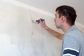 Construction man worker repairing a crack wall of a home, plastering cement on wall. Builder applying white cement to a Royalty Free Stock Photo