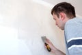 Construction man worker repairing a crack wall of a home, plastering cement on wall. Builder applying white cement to a Royalty Free Stock Photo