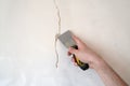 Construction man worker repairing a crack wall of a home, plastering cement on wall. Builder applying white cement to a Royalty Free Stock Photo