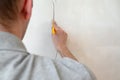 Construction man worker repairing a crack wall of a home, plastering cement on wall. Builder applying white cement to a Royalty Free Stock Photo