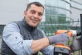 construction man working with cordless electrical screwdriver on metal fence