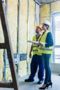 Construction manager and architect checking the insulation works Royalty Free Stock Photo