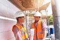 Construction manager and architect on site during the construction of a house - planning and control on site - teamwork Royalty Free Stock Photo