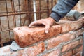 Construction mason,  industry worker laying bricks and building walls on construction site. Detail of hand adjusting and placing Royalty Free Stock Photo