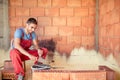 Construction mason worker, bricklayer building brick walls with spatula and mortar Royalty Free Stock Photo