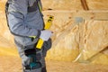 Construction mason worker with building level and screwdriver on attic with environmentally friendly Royalty Free Stock Photo