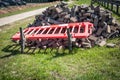 Construction Materials with Fallen Safety Barrier on Grass During Urban Sidewalk Renovation Royalty Free Stock Photo