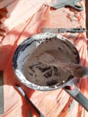 Construction mess, trowel in dried plaster in a bucket, workflow interrupted for a break, out of materials, white coating Royalty Free Stock Photo