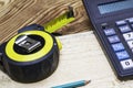 Construction meter-tape measure calculator for calculations pencil and wooden board are on the workbench Royalty Free Stock Photo