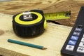 Construction meter-tape measure calculator for calculations pencil and wooden board are on the workbench Royalty Free Stock Photo