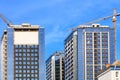 The glass facade, a reflection of the blue sky and crane near a modern concrete building under construction Royalty Free Stock Photo