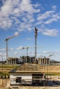 Construction of a monolithic house made of reinforced concrete against the background of a cloudy sky. Tower cranes. Construction Royalty Free Stock Photo