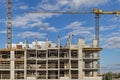 Construction of a monolithic house made of reinforced concrete against the background of a cloudy sky. Tower cranes. Construction Royalty Free Stock Photo