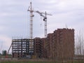 Construction of a multi-storey brick house on an industrial site with a crane Royalty Free Stock Photo