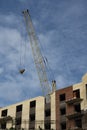 Construction of a multi-storey brick house with a yellow crane. Royalty Free Stock Photo