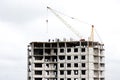 The construction of a multi-storey building of brick and concrete. Fragment of a modern house and a construction crane. Close-up Royalty Free Stock Photo