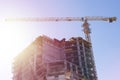 Construction of a multi-storey residential building against the background of the bright light of the sun. Royalty Free Stock Photo