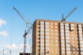 The construction of a new apartment building, against the background of the blue sky, a high-rise construction crane Royalty Free Stock Photo