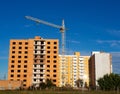 Construction of new apartment building. Facade of unfinished brick multistory building with crane and new dwelling on the Royalty Free Stock Photo