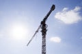 Tower building crane against the blue sky and sun. Construction of a new house. Construction of new buildings with a crane. Tower Royalty Free Stock Photo