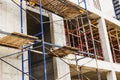 Construction of a new monolithic reinforced concrete house. Scaffolding on the facade of a building under construction. Working at Royalty Free Stock Photo