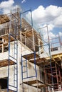 Construction of a new monolithic reinforced concrete house. Scaffolding on the facade of a building under construction. Working at Royalty Free Stock Photo