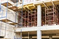 Construction of a new monolithic reinforced concrete house. Scaffolding on the facade of a building under construction. Working at Royalty Free Stock Photo