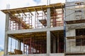 Construction of a new monolithic reinforced concrete house. Scaffolding on the facade of a building under construction. Working at Royalty Free Stock Photo